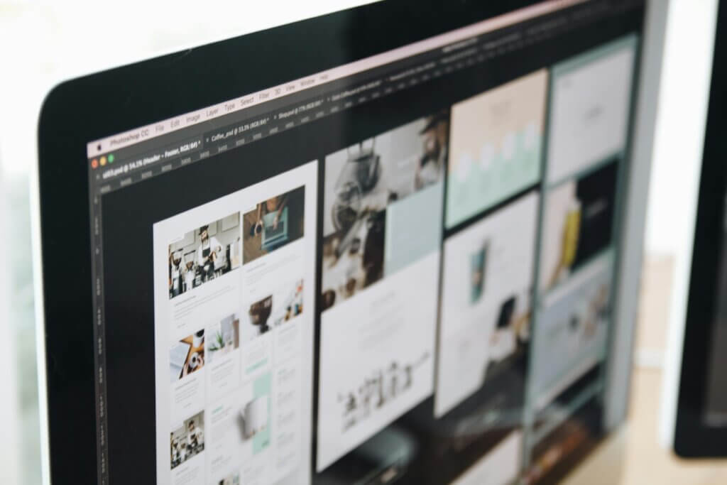 Close-up of a computer screen displaying a website design interface with various content blocks and images